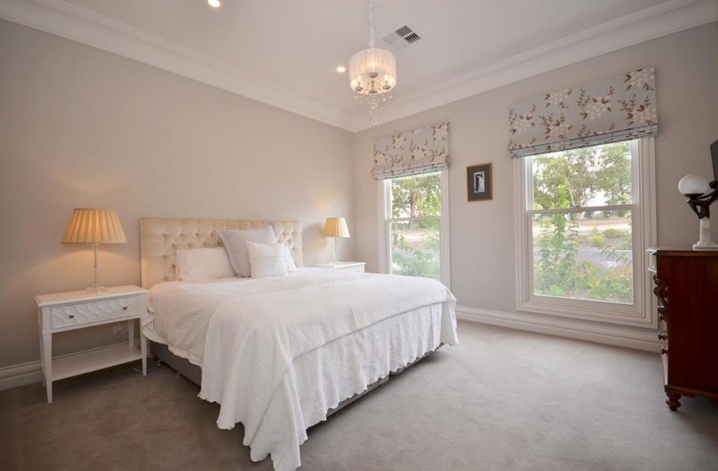 Guest bedroom with neutral finishes and floral Roman blinds