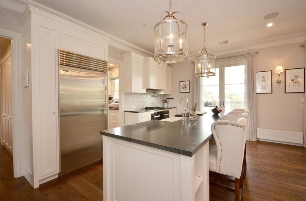 Country style kitchen with white cabinetry, island bench and pendant lighting
