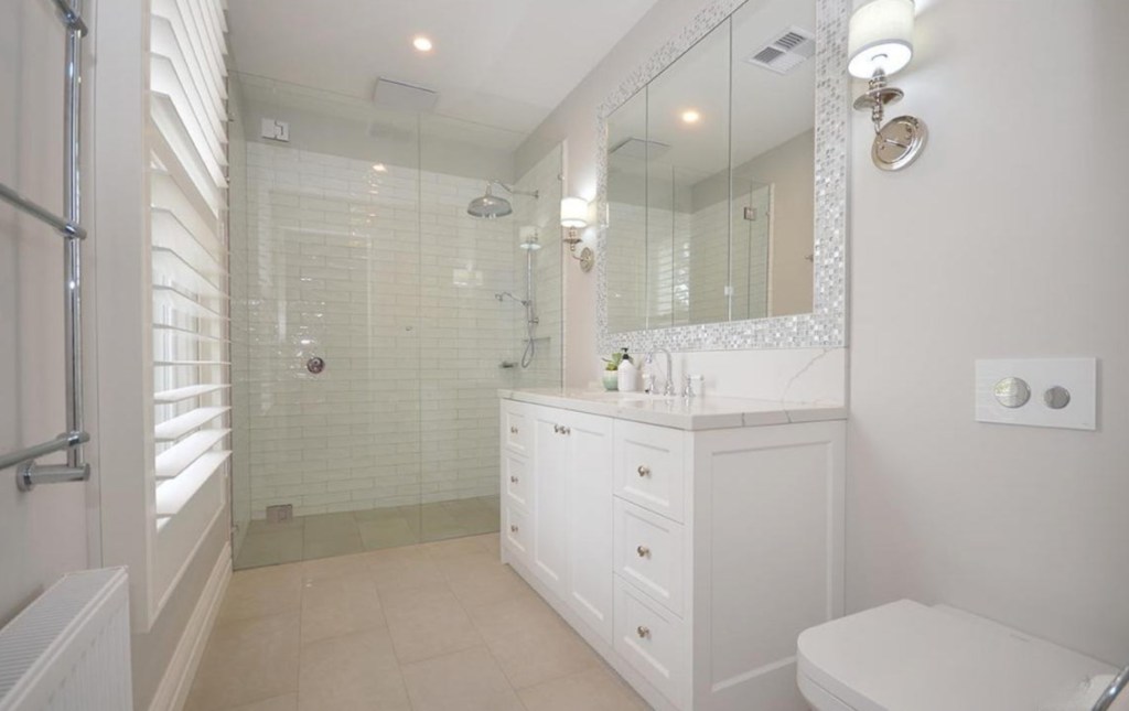 Ensuite with white vanity, mirrored cabinet and walk in shower