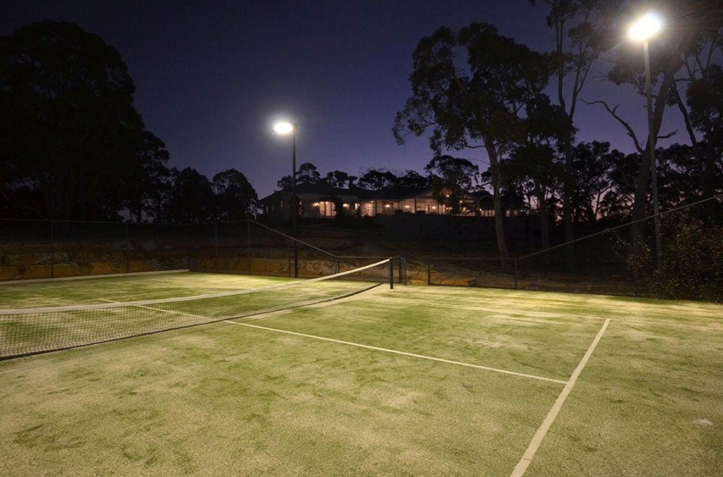 Outdoor living area beside the home and tennis court