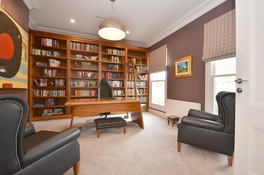 Home study with floor to ceiling timber bookshelves and desk